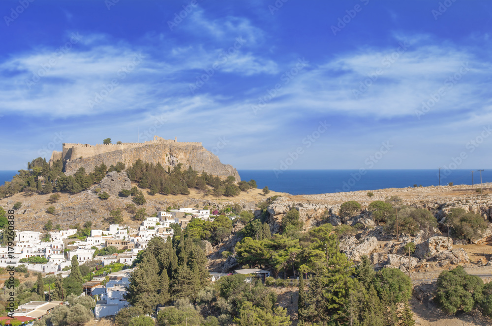 Castle view Acropolis of city Lindos of Rhodes island with big blue cloudy sky