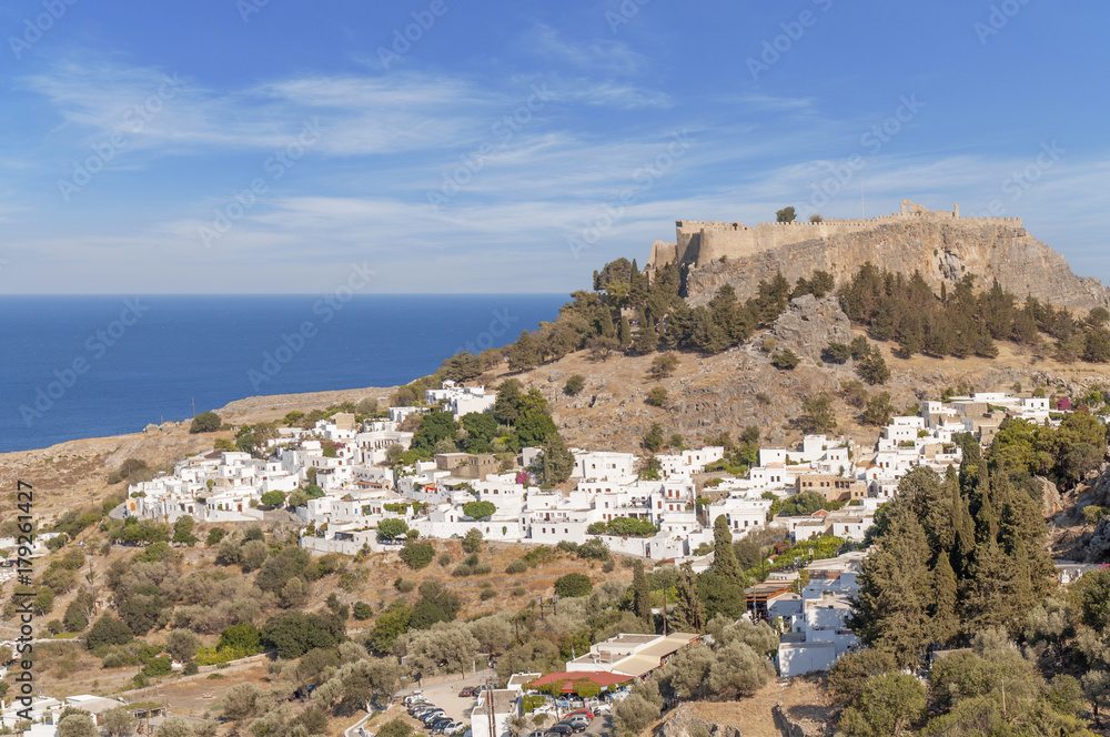 Castle view Acropolis of city Lindos of Rhodes island with big blue cloudy sky