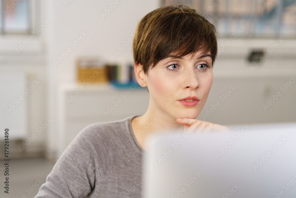 frau schaut nachdenklich auf ihren computer frau schaut nachdenklich auf ihren computer
