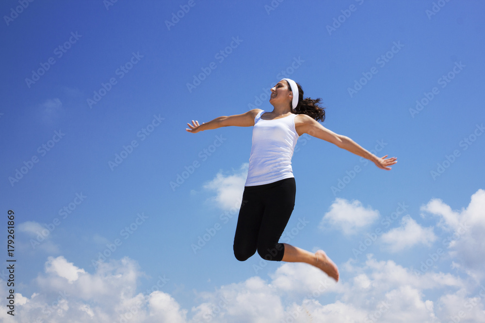 happy young woman jumping in the air happy young woman jumping in the air