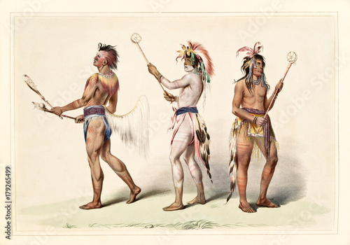 Native indian guys dressing the ball player traditional costumes. Old watercolor illustration by G. Catlin, Catlin's North American Indian Portfolio, Ackerman, New York, 1845 photo