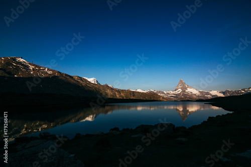 morning mountain matterhorn with a lake in shadow. Switzerland Zermatt