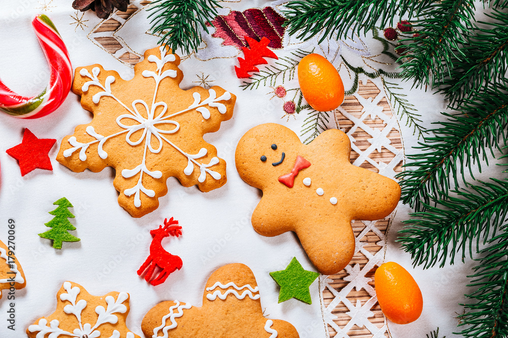 Christmas gingerbread cookies homemade with branches of Christmas tree and New Year decor on table with white tablecloth. Merry Christmas postcard Christmas gingerbread cookies homemade with branches of Christmas tree and New Year decor on table with white tablecloth. Merry Christmas postcard