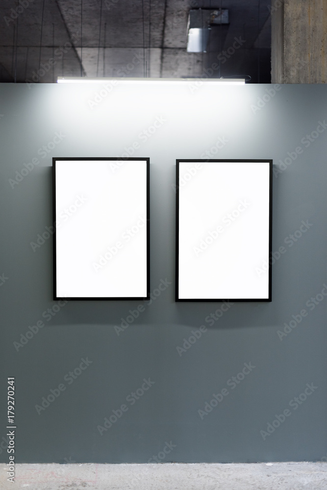 Mock up. Blank picture frames on gray wall in the loft interior. Gallery wall with empty poster frames indoor. Mock up. Blank picture frames on gray wall in the loft interior. Gallery wall with empty poster frames indoor.
