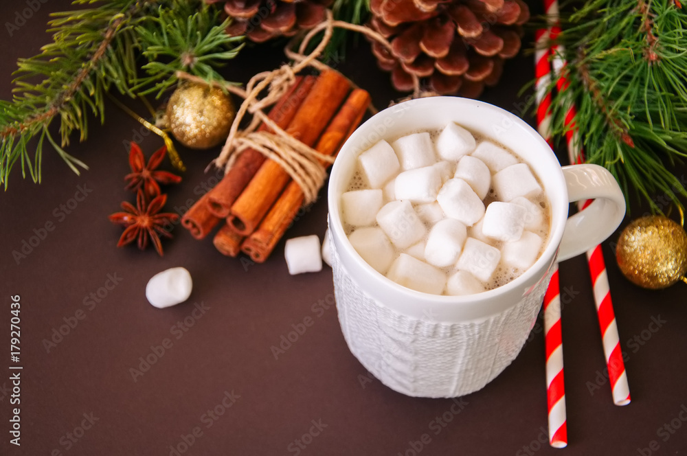 Hot chocolate with marshmallows, fir tree branches, cones, cinnamon and christmas balls on a brown background. Hot chocolate with marshmallows, fir tree branches, cones, cinnamon and christmas balls on a brown background.