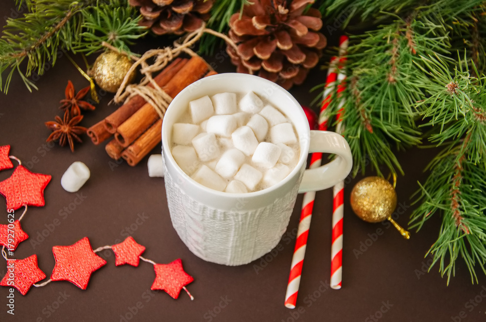 Hot chocolate with marshmallows, fir tree branches, cones, cinnamon and christmas balls on a brown background. Hot chocolate with marshmallows, fir tree branches, cones, cinnamon and christmas balls on a brown background.