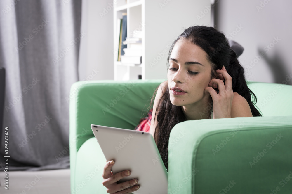 Attractive woman using tablet on sofa Attractive woman using tablet on sofa