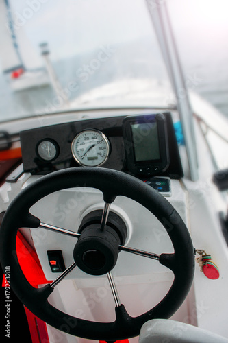 at the wheel of a yacht, in front of the steering wheel, a journey by sea, a powerful boat
