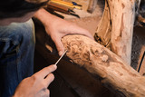 close up picture of woodcarver at work, handcrafting with wood  