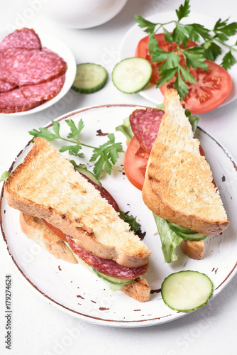 Club sandwiches with salami, tomatoes, cucumber