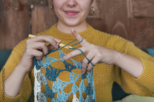 Young woman crocheting doily, close-up photo