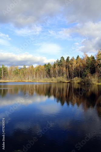beautiful view of lake and autumn wood and sky with clouds