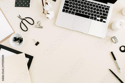 Workspace with laptop, female accessories on beige background. Flat lay, top view women business concept. photo