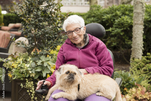 Schilderij op canvas Independent Elderly Woman Outside in Wheelchair with Dog in Lap