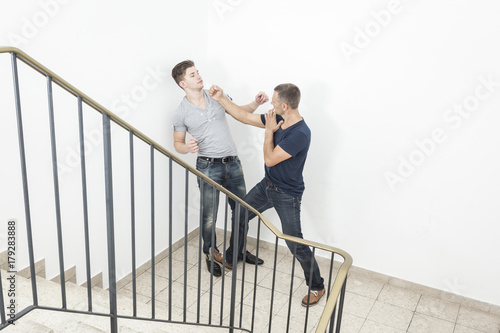 a two men fight at the staircase