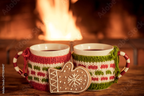 Two Christmas cups of mulled wine near fireplace photo