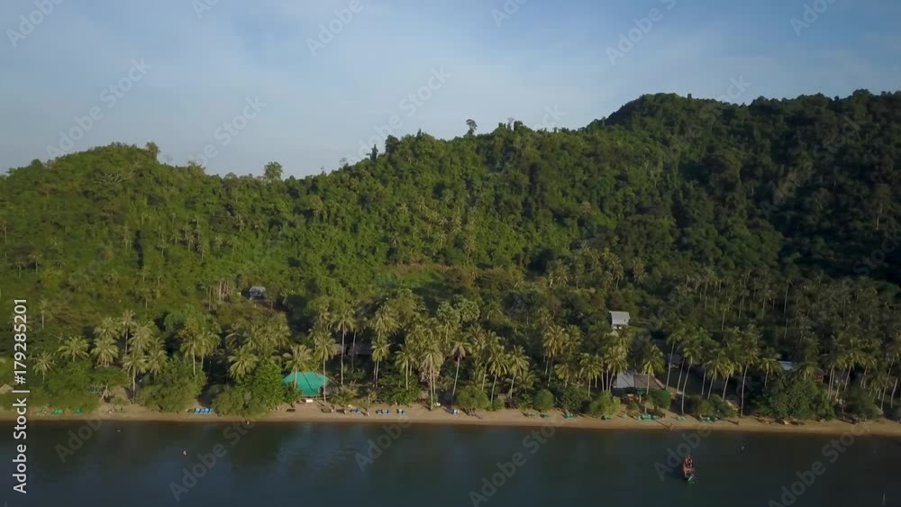Aerial camera sliding to the left slowly showing a view of a typical southeast Asia backpacker resort at sunrise or sunset with Kep, Cambodia in the distance. Aerial camera sliding to the left slowly showing a view of a typical southeast Asia backpacker resort at sunrise or sunset with Kep, Cambodia in the distance.