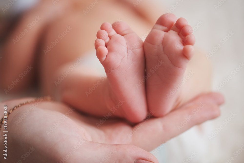 mother holds little foot of newborn baby mother holds little foot of newborn baby