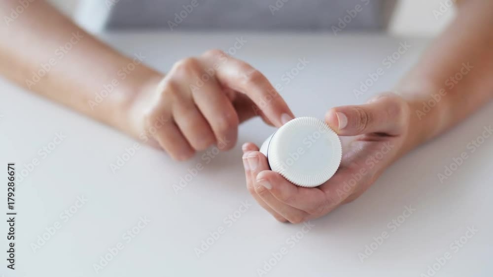 woman hands opening jar of medicine pills woman hands opening jar of medicine pills