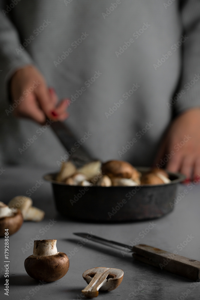 Mushrooms in vintage pan on gray wooden background