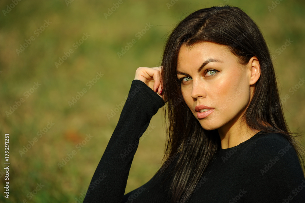 Close-up portrait of beautiful brunette woman outdoors.