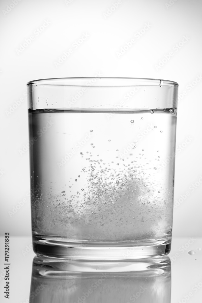 Aspirin, vitamins, fizzing in a glass of water. Aspirin, vitamins, fizzing in a glass of water.