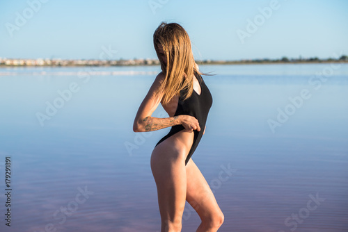 Young girl in black swimsuit at the beach