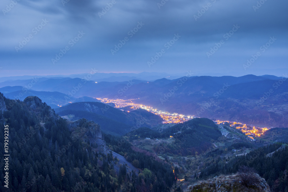Bulgarian city Smolyan before dawn in the rain. The shining lights of the city are like a river in the heart of Rodopi mountain.
