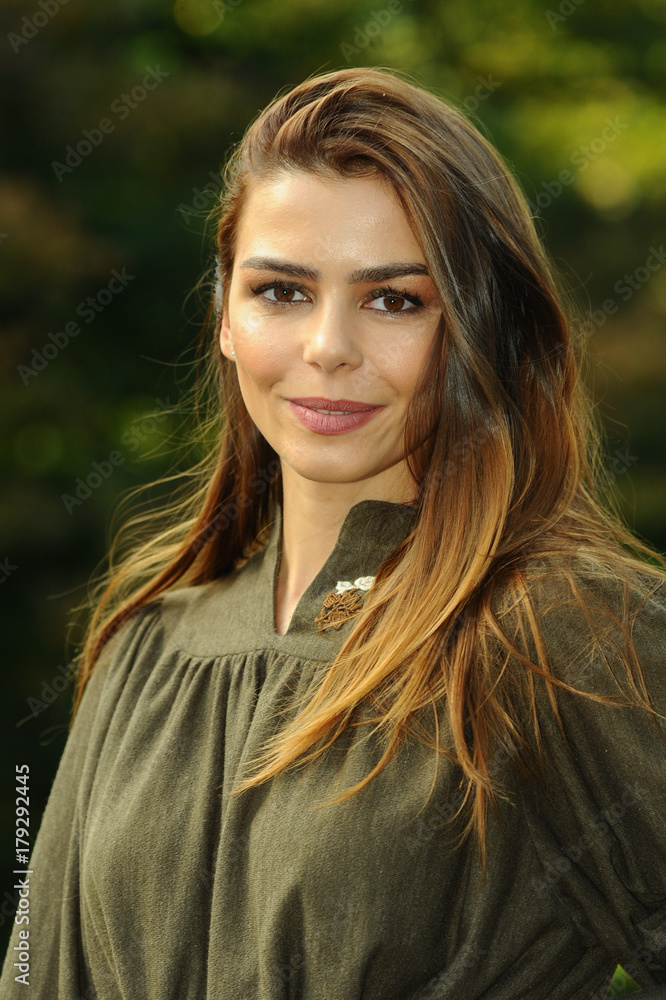 Obraz premium Outdoors portrait of emotional young beautiful young woman on autumn foliage background.