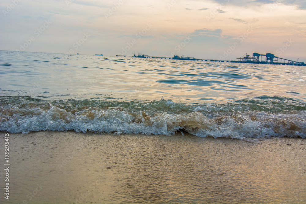 Fototapeta premium Artistic photo. Close-up on a wave withdrawing on the sand of a beach in the sunset