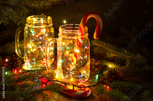 Christmas fairy garland lights in a glass jar shine in the night darkness.