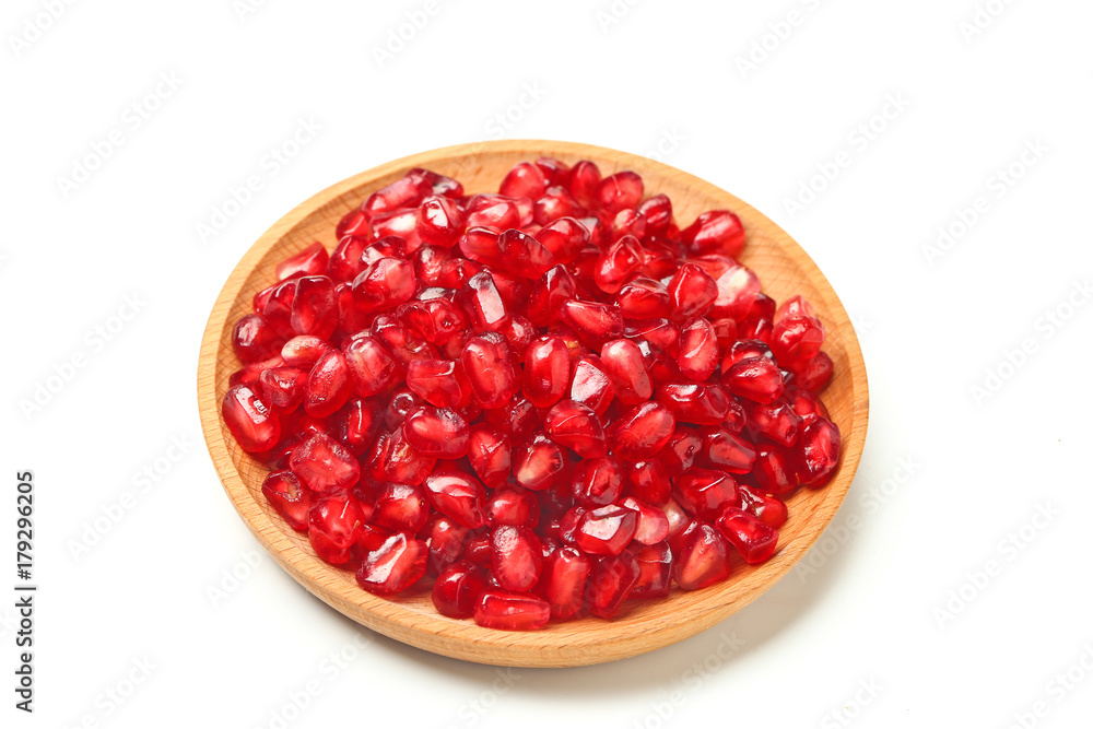 pomegranate seeds in wooden plate isolated on white background pomegranate seeds in wooden plate isolated on white background