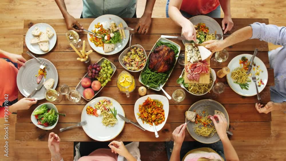 group of people eating at table with food