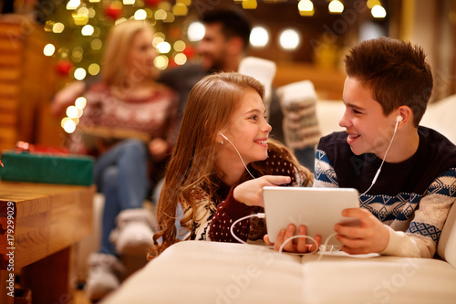 Canvastavla Girl and boy listening music on tablet together