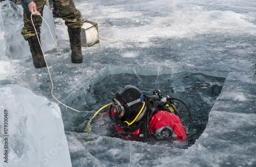 diver plunges into the hole in the ice of lake Baikal