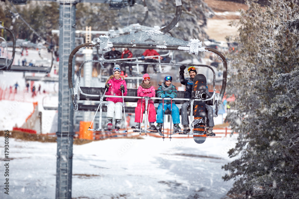Naklejka premium Skiers at the ski resort on a background of ski-lifts, forests, mountains at the sunny day. Ski season