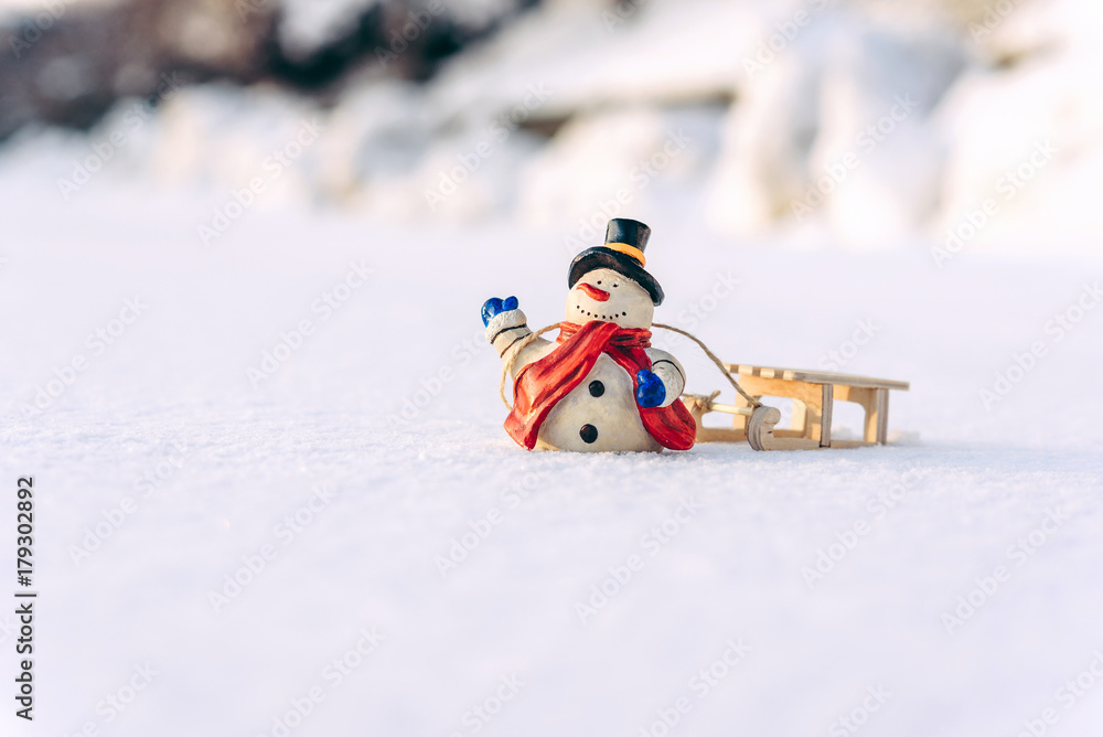 Naklejka premium Closeup christmas decorations snowman and sled on the snow.