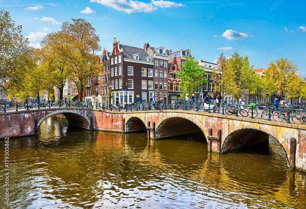 Fototapeta premium Bridge over channel in Amsterdam Netherlands houses river Amstel
