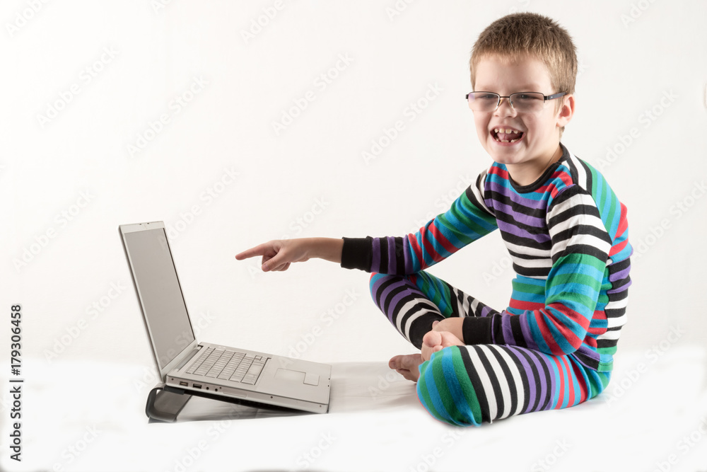 A Caucasian boy with glasses tries to work with a computer and the Internet. The guy gets vivid emotions.