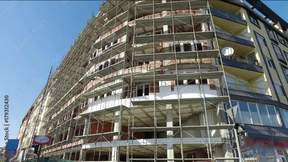 The building under construction with the scaffolind at the construction site The building under construction with the scaffolind at the construction site