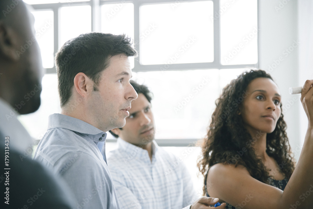 Businesswoman writing on whiteboard in meeting Businesswoman writing on whiteboard in meeting