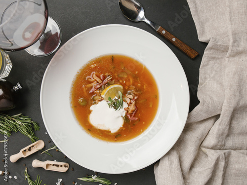 Brown soup in bowl with sour cream photo