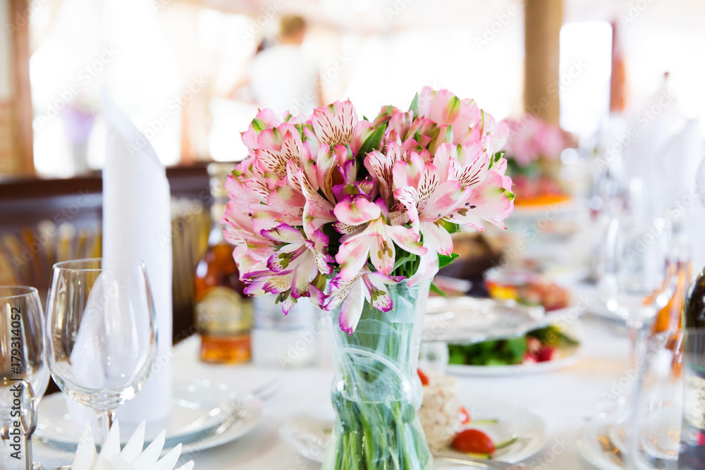 Served table in the restaurant with flower composition