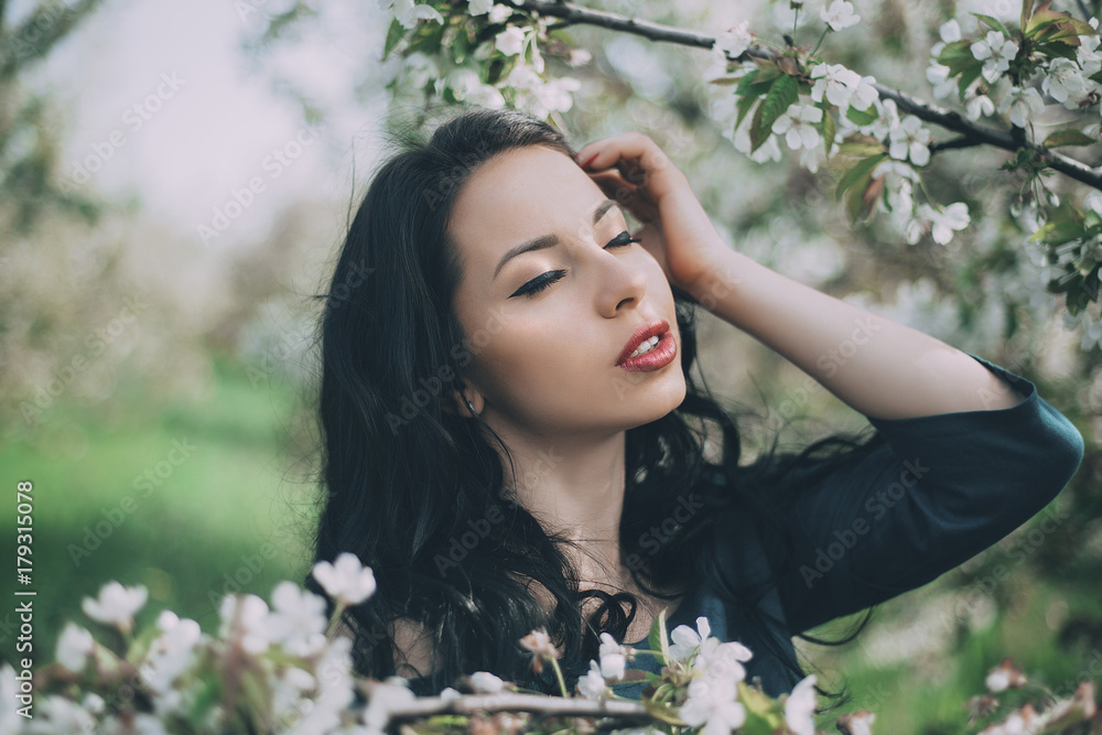 Caucasian woman with hand and hair near flowering tree Caucasian woman with hand and hair near flowering tree