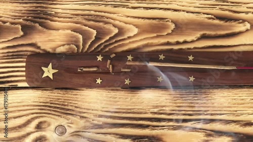 TOP VIEW: Incense sticks burning iindian agarbatti smoke aroma incense stand burning incense sticks background close up smoke dynamic beautiful calm relax concept Incense stick bowel on a wooden table