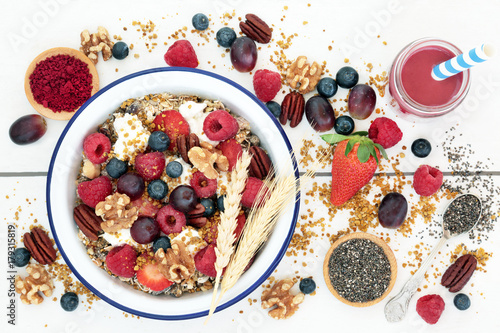 Macrobiotic health food for breakfast concept including acai berry smoothie and powder, granola, pollen grain,  berry fruit, chia seed and nuts, high in protein, omega 3,  antioxidants and vitamins. 