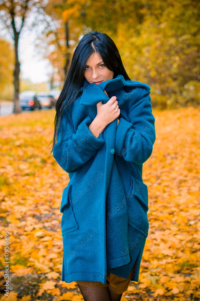 Portrait of young beautiful woman in autumn blue oversized coat. Brunette fashion woman walking outdoor against an autumn nature landscape High fashion photo of elegant woman stylish in boho style Portrait of young beautiful woman in autumn blue oversized coat. Brunette fashion woman walking outdoor against an autumn nature landscape High fashion photo of elegant woman stylish in boho style