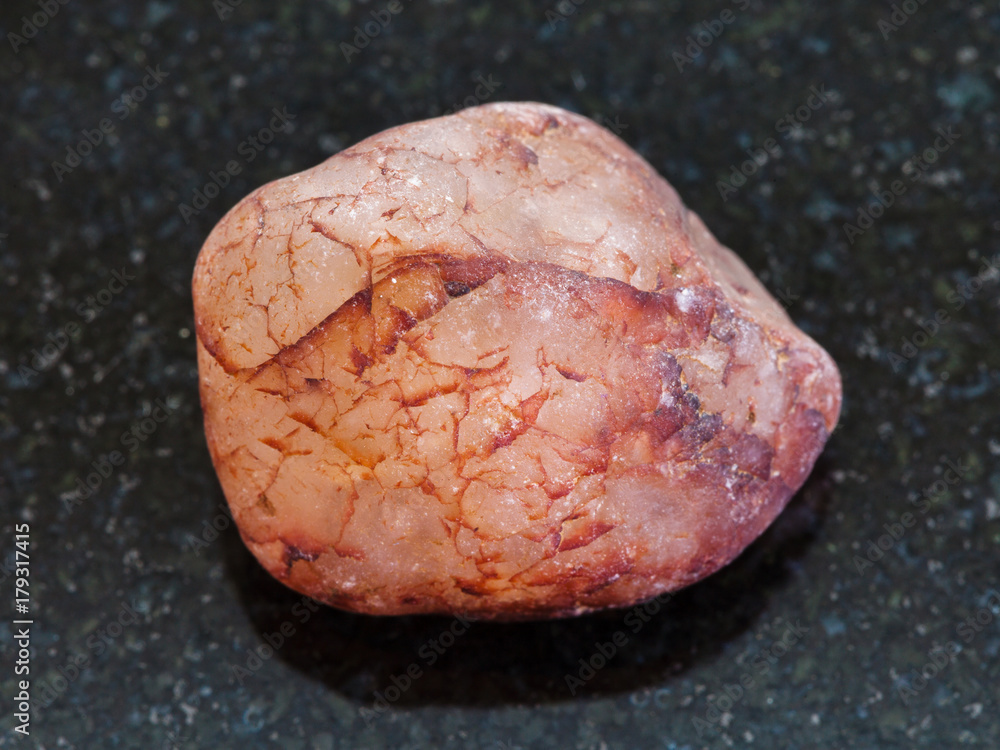 pebble of rose quartz stone on dark background pebble of rose quartz stone on dark background