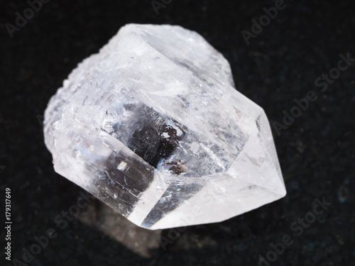 raw rock-crystal of quartz gemstone on dark