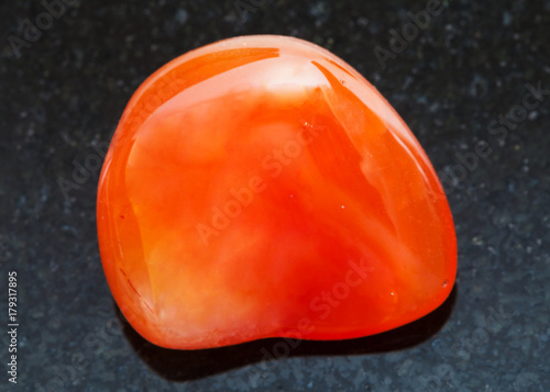 polished carnelian gem on dark g background